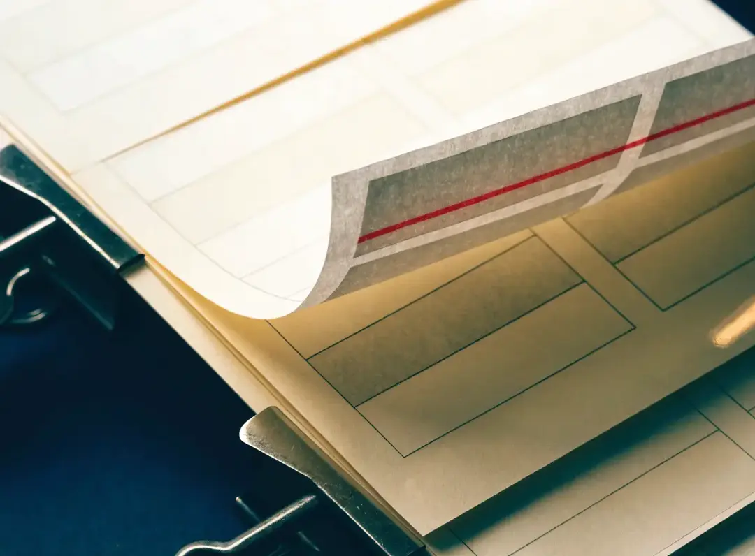 Layered blank audit sheets showing one red line across overlapping page structures
